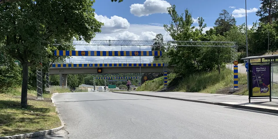 Höjdhinderportal med gul och blå reflex över en bilväg